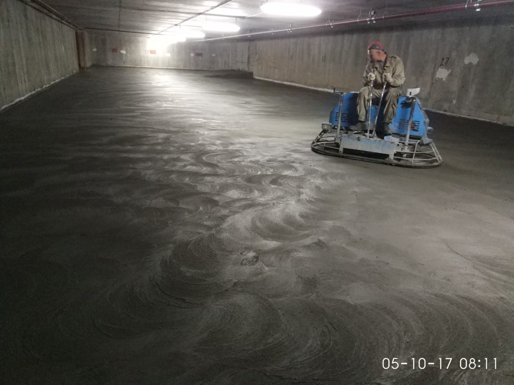бетонный пол, затирка сухого минерального упрочнителя по технологии ТОППИНГ на подземном паркинге